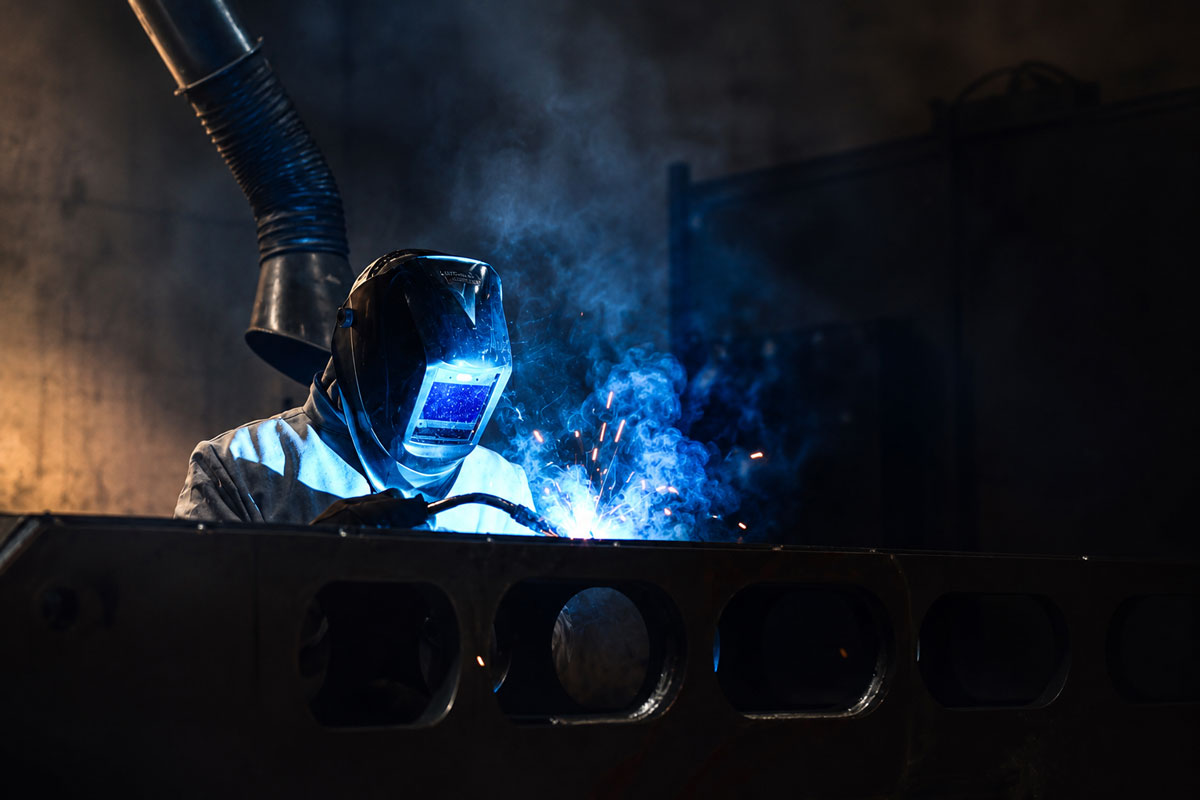 Operatore Metal88 esegue una saldatura  su una struttura in acciaio all'interno del reparto produttivo.